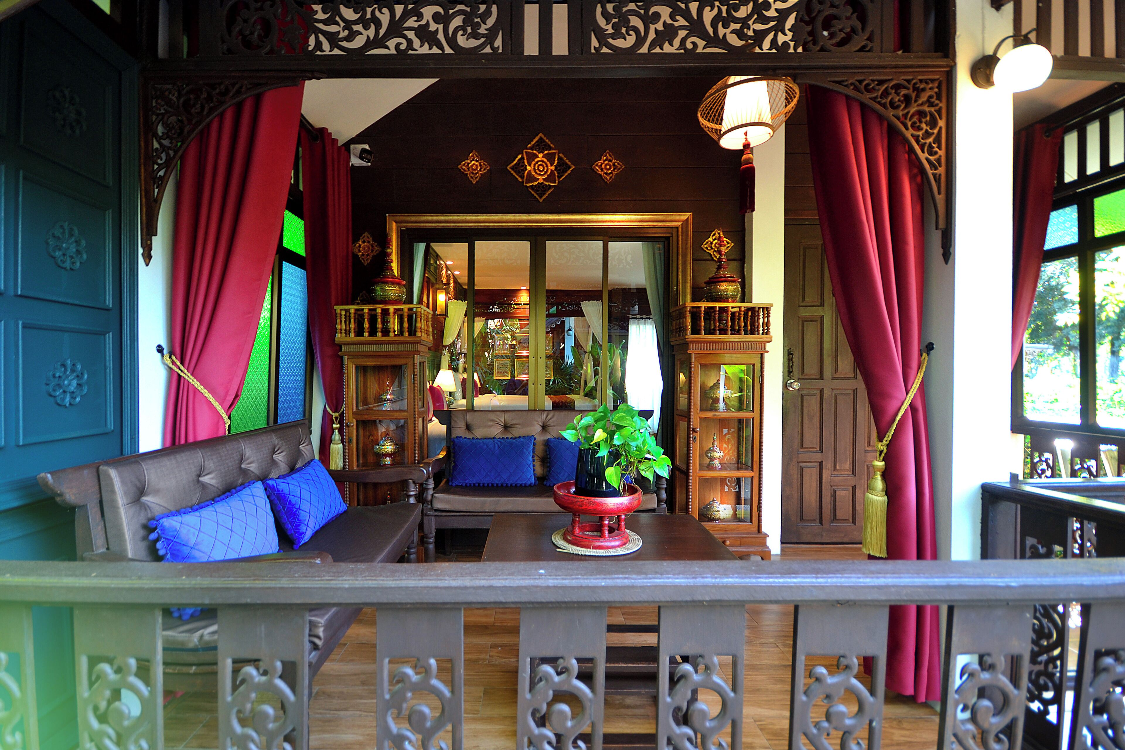 A room with a sofa, a table with a plant, and a decorative railing.