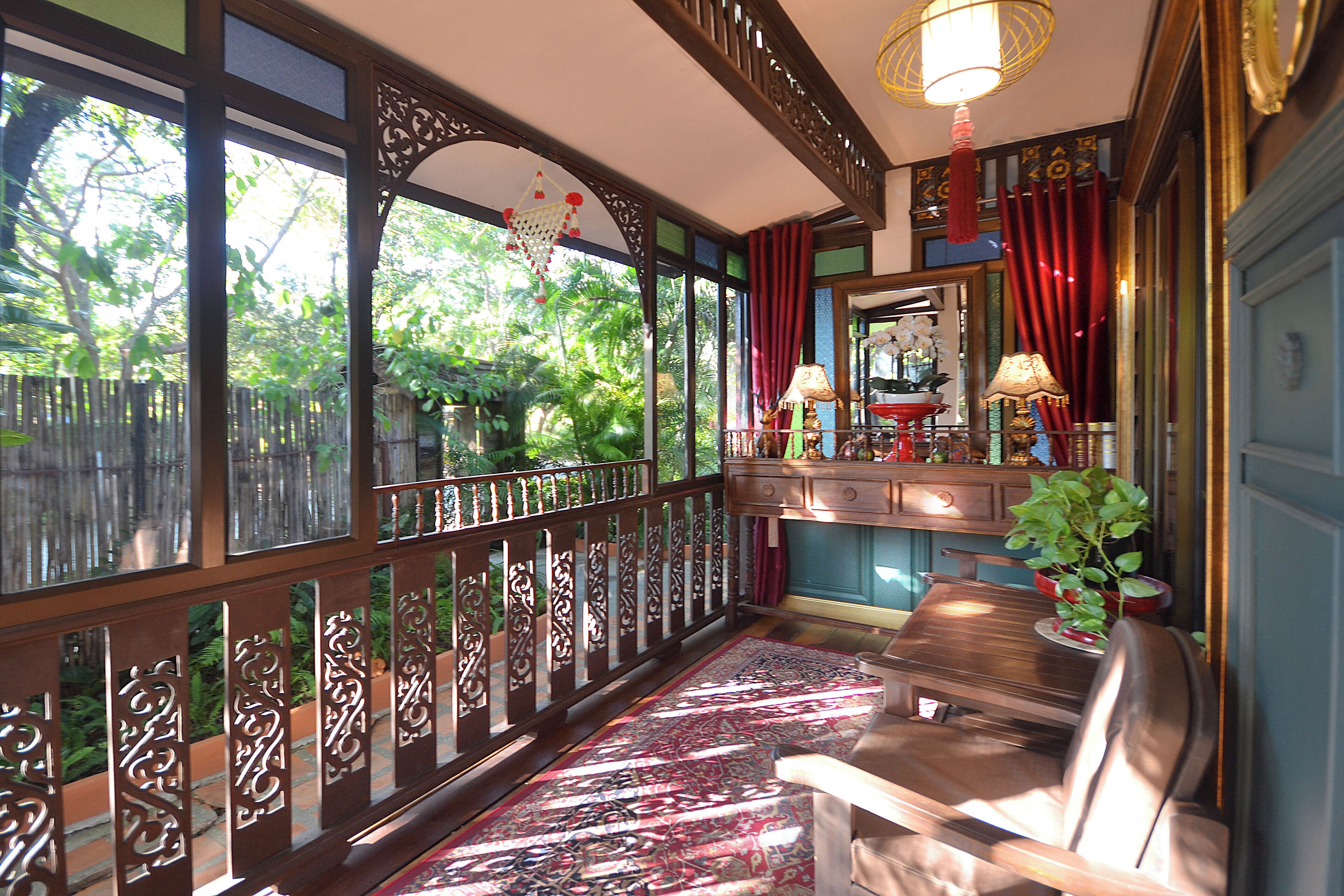 A room with a wooden bench, a patterned rug, and a view of greenery outside.