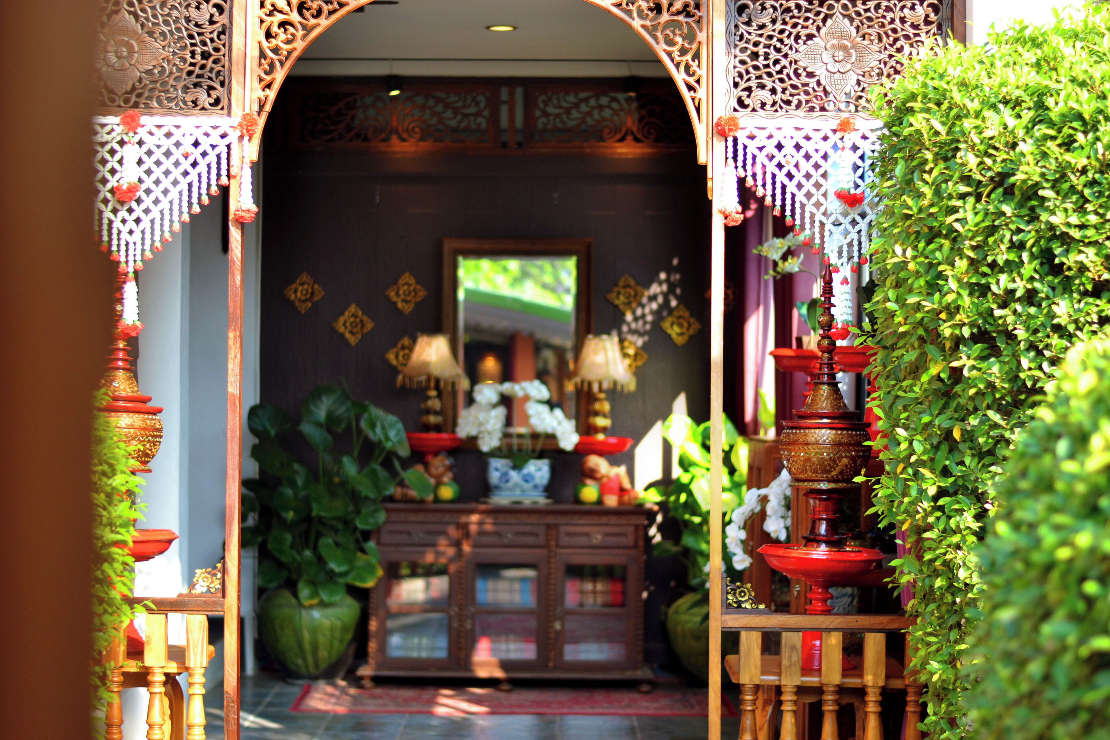 An ornate entrance with a wooden cabinet and decorative items.