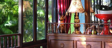 A wooden dresser with drawers, a lamp, and a decorative deer head.