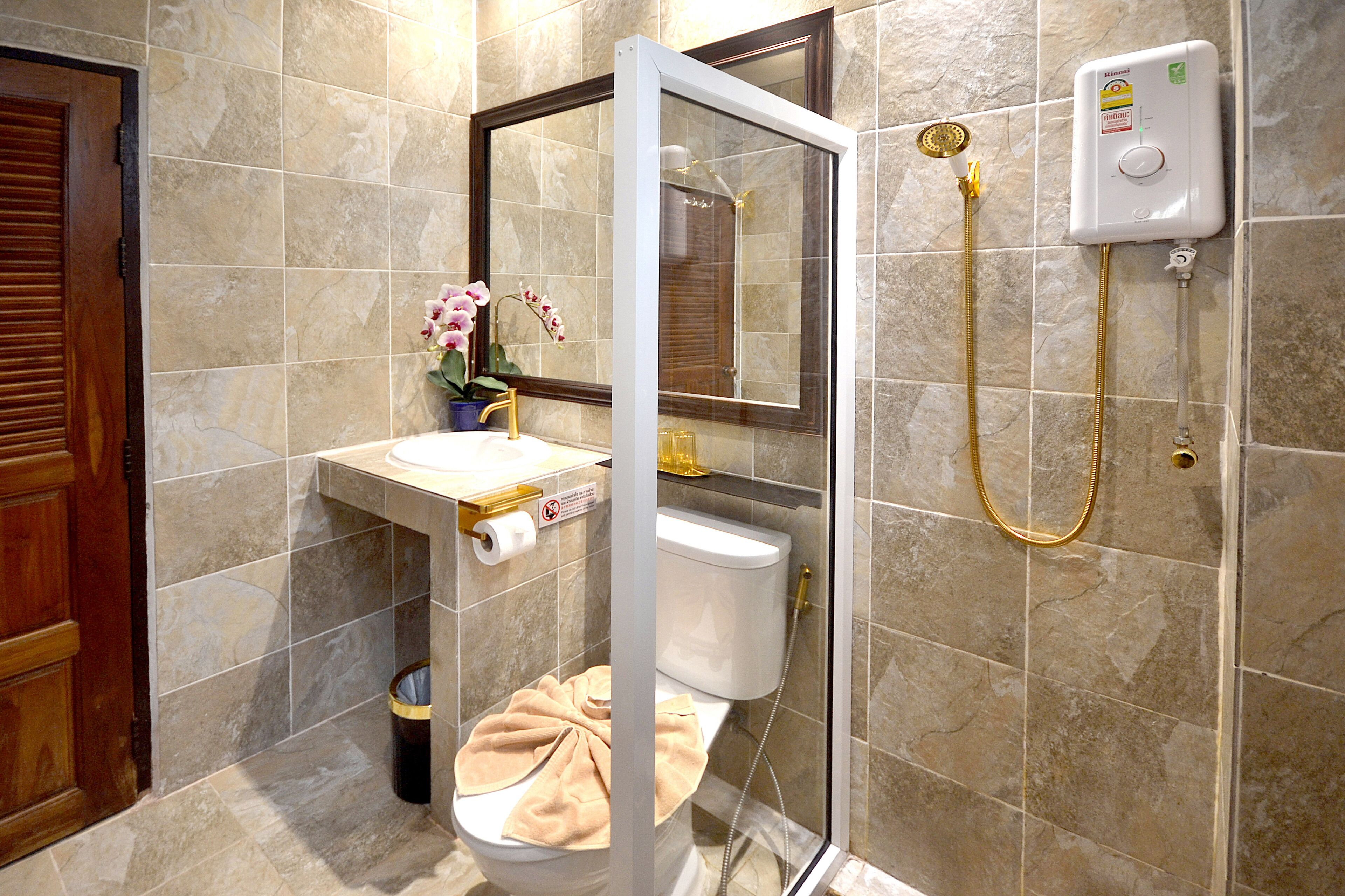A bathroom with a toilet, sink, and shower.