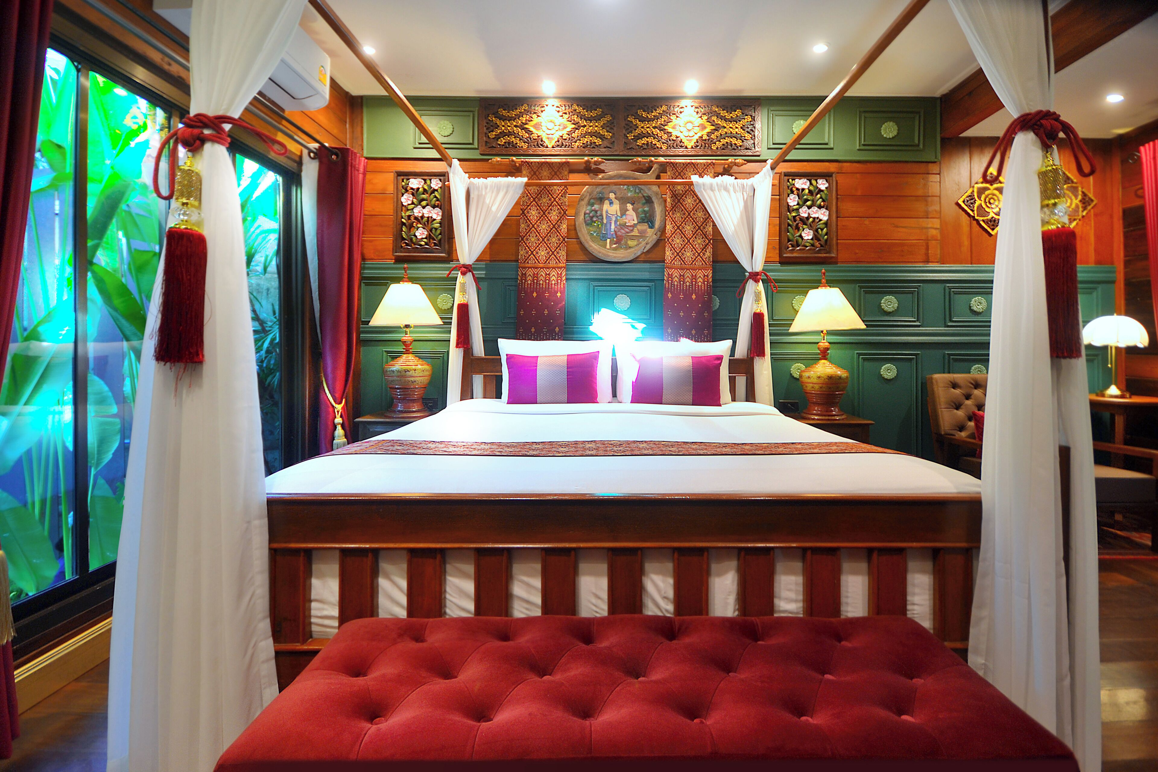 A room with a bed, curtains, a window with a view, and a lamp.