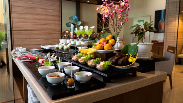 Un buffet con diversi piatti, frutta e fiori.