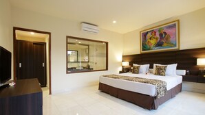 A hotel room with a large bed, a TV, a mirror, and a painting on the wall. - Arnawa Bungalow (Ubud)