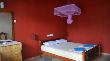 Una habitación con una cama de madera, un aparador y un espejo.