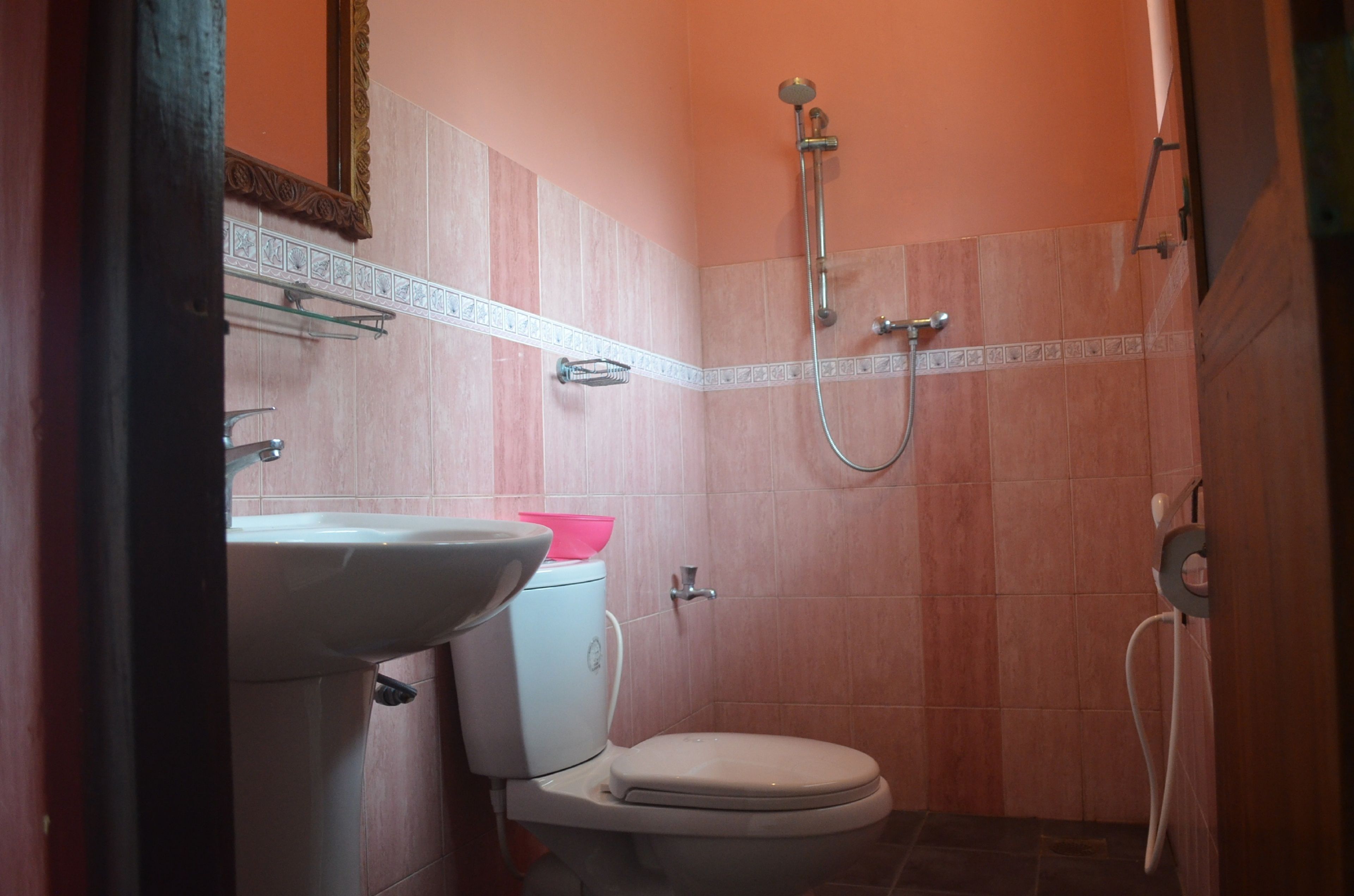 A small bathroom with a toilet, sink, and shower.