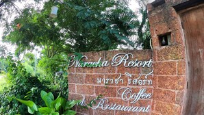 A brick wall with a sign for Narachana Resort Coffee Restaurant.