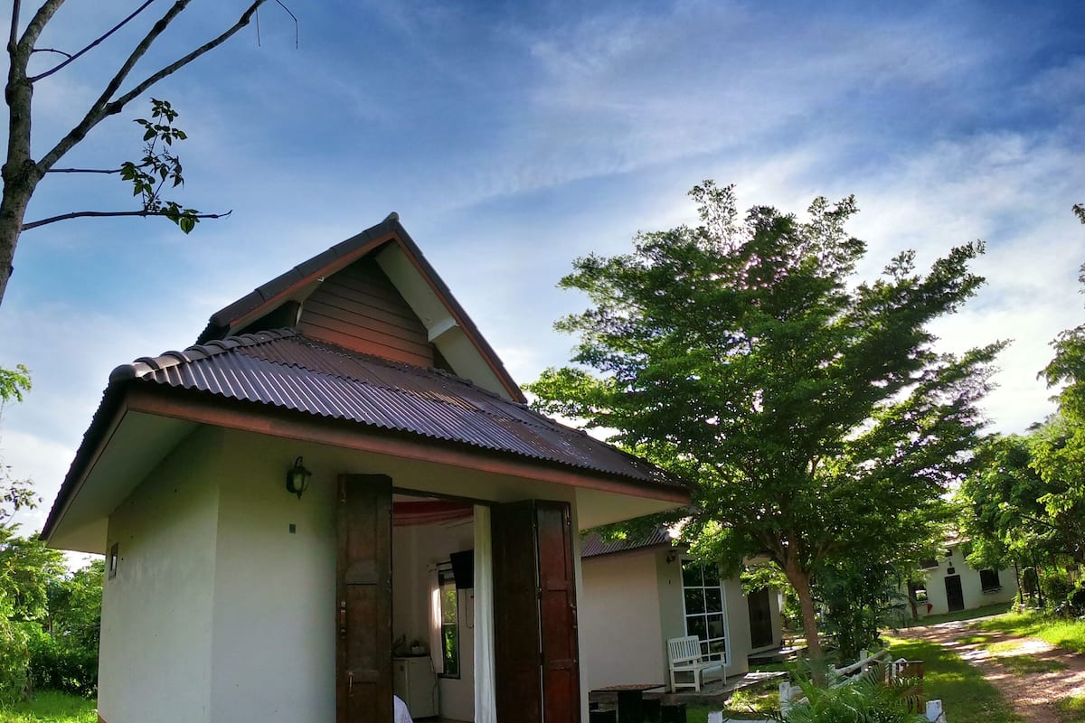 A small, single-story building with a sloped roof, a door, and a window.