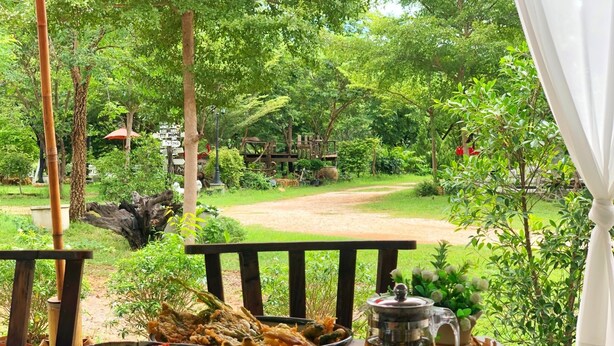 A dining table with a bowl of food, a pitcher of tea, and a cup of tea.