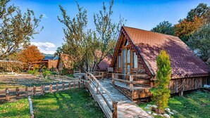 Ein rustikales Blockhaus mit einer Holzdiele und einem strohgedeckten Dach.