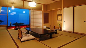 A traditional Japanese room with tatami flooring, a low table, and a sliding door. - Atami Taikansou (Atami)