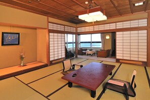 A traditional Japanese room with tatami flooring, a low table, and a sofa.