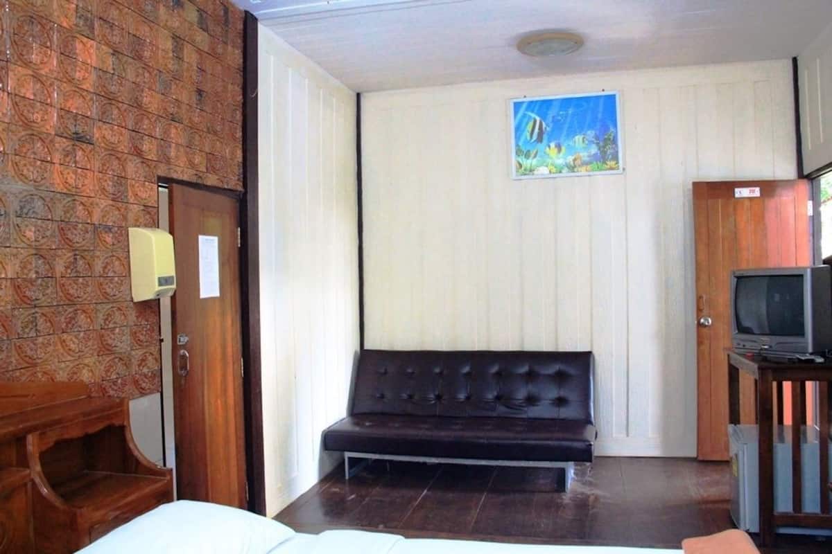 A room with a wooden bench, a television on a stand, and a painting on the wall.