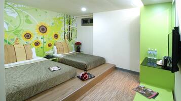 A room with two beds, a green wall, a small window, and a shelf with toiletries.