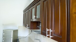Una cocina con gabinetes de madera, un refrigerador de acero inoxidable y un microondas integrado.