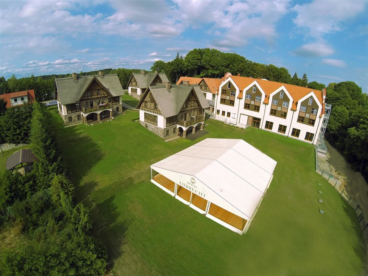 A large hotel with multiple buildings, a central courtyard, and a covered area.
