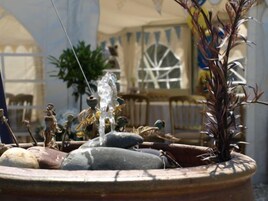 Una fuente con varios chorros de agua, rodeada de rocas y elementos decorativos.