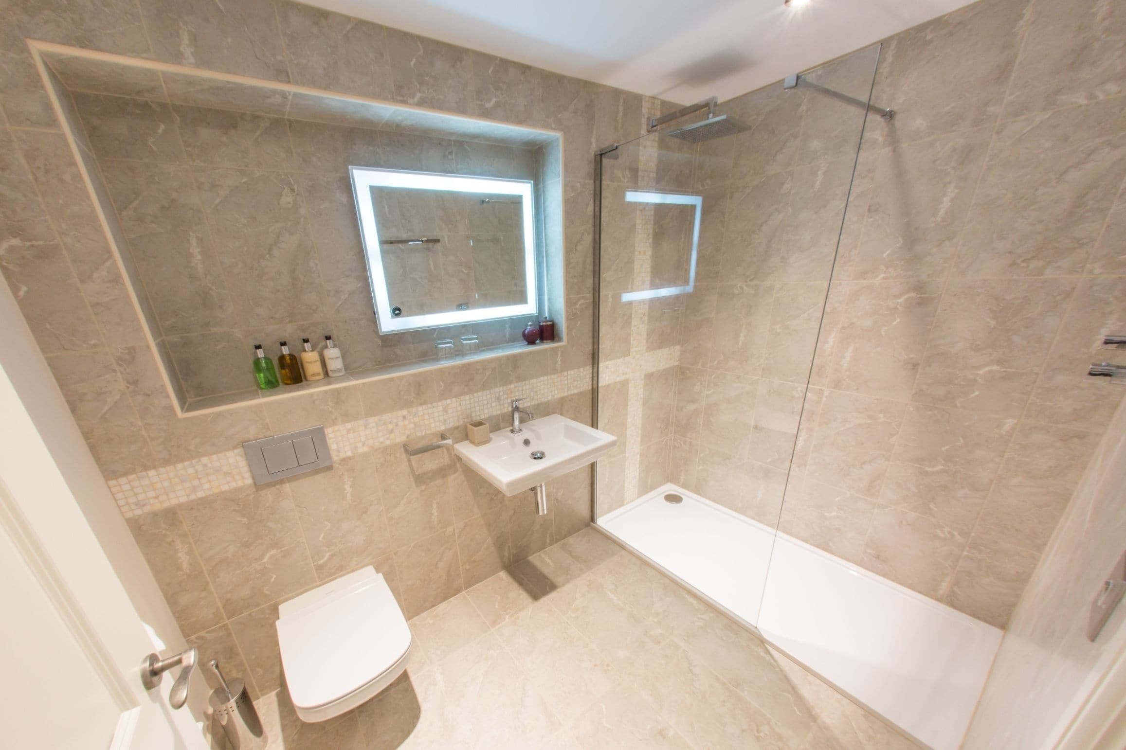 A modern bathroom with a bathtub, toilet, sink, and a glass-enclosed shower.
