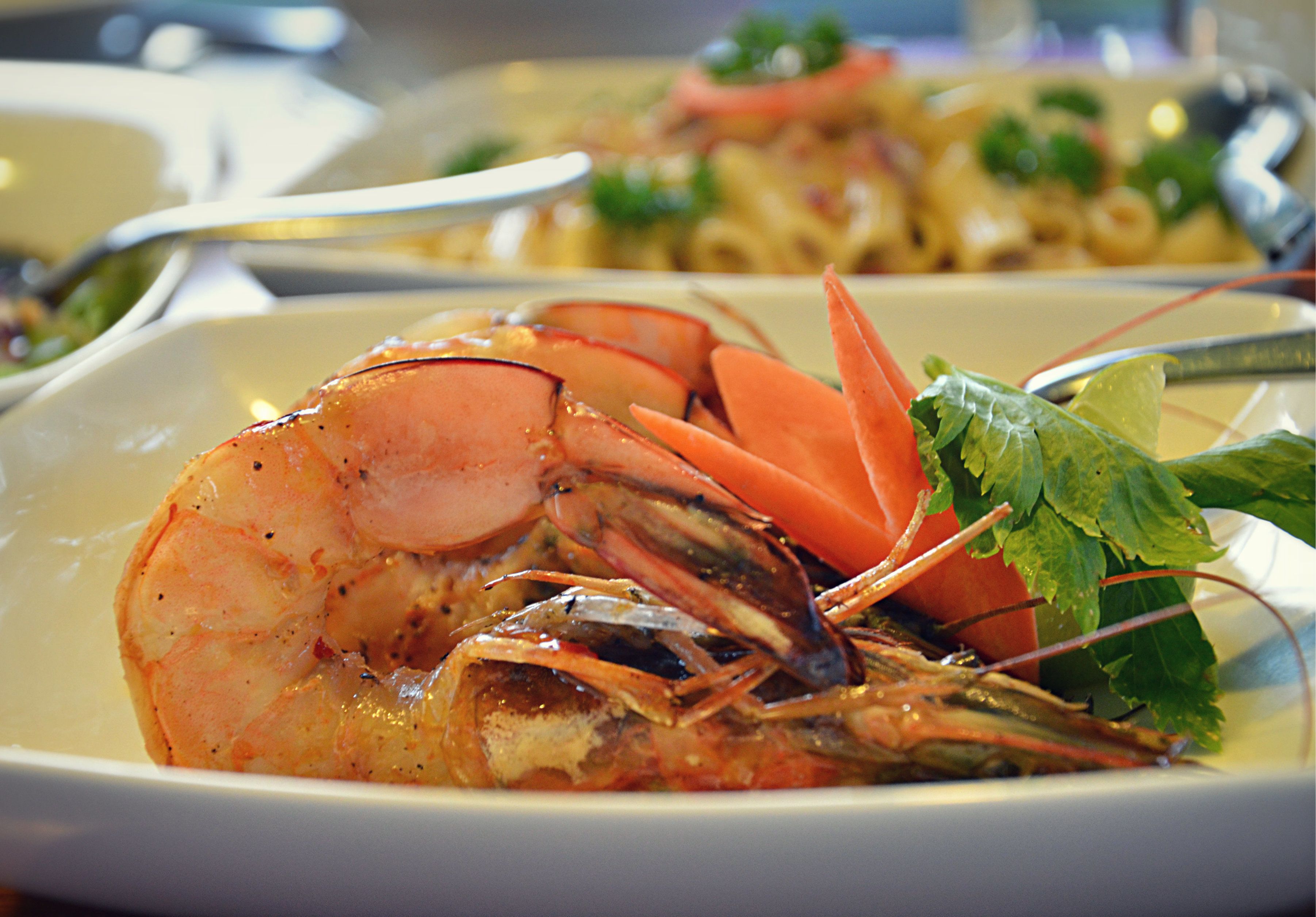 Un plat de fruits de mer composé de crevettes et d’une queue de homard, agrémenté d’herbes fraîches.