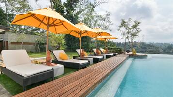 Una piscina al aire libre, sillones reclinables de piscina