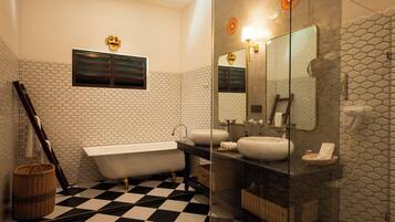 Un bagno con pavimento a scacchi, una vasca, uno specchio grande e una parete rivestita di piastrelle esagonali.