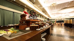 A buffet setup with a variety of food items, a 'Merry Christmas' sign, and a wooden counter. - Yi Yuan Resort (Shoufeng)