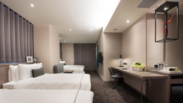 A hotel room with two beds, a desk, a chair, a mirror, and a TV. - Hotel rêve Taichung (Taichung)