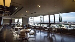 A spacious indoor area with tables and chairs arranged for dining or meetings, large windows offering a city view, and a modern ceiling design. - Hotel rêve Taichung (Taichung)