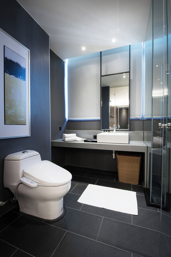 Un baño moderno con inodoro, lavabo y cabina de ducha de vidrio.