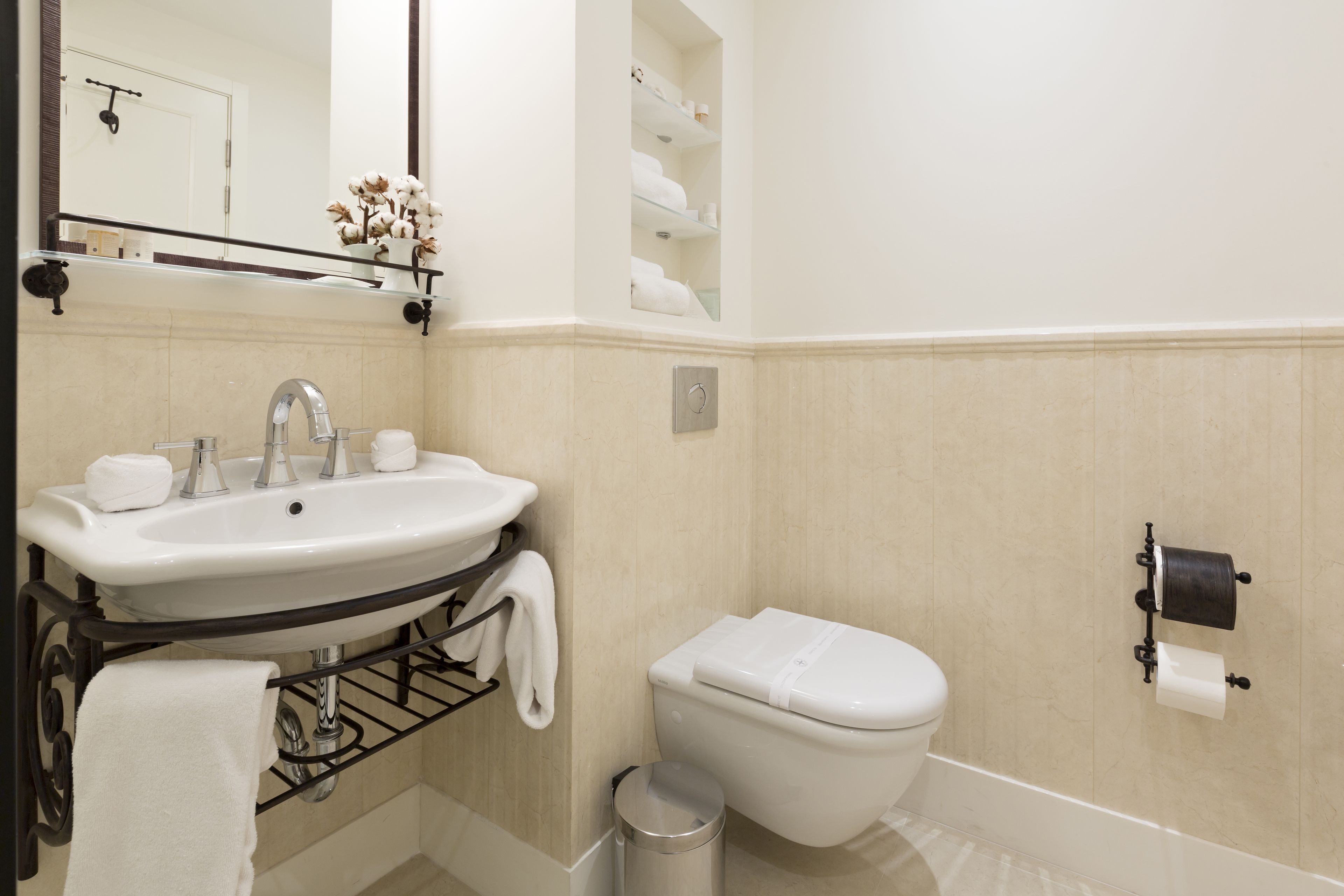 A bathroom with a sink, toilet, and a mirror.