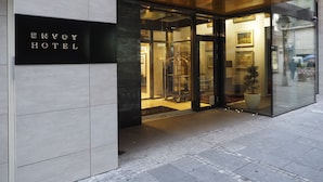 The entrance of the Envoy Hotel with a modern design, featuring a glass door and a visible interior with a mannequin. - Envoy Hotel Belgrade (Belgrade)