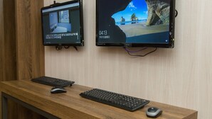 Zwei Monitore auf einem Schreibtisch mit Tastaturen und Mäusen.