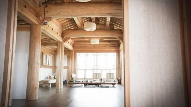 A spacious room with wooden beams, large windows, and a bench. - Happy Village Syeobul Guesthouse (Gyeongju)