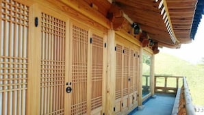 A traditional wooden building with multiple sliding doors and a covered porch area. - Happy Village Syeobul Guesthouse (Gyeongju)