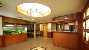 A lobby with a reception desk, a large fish tank, and a chandelier. - Taoyuan Hua Yue Hotel (Taoyuan City)