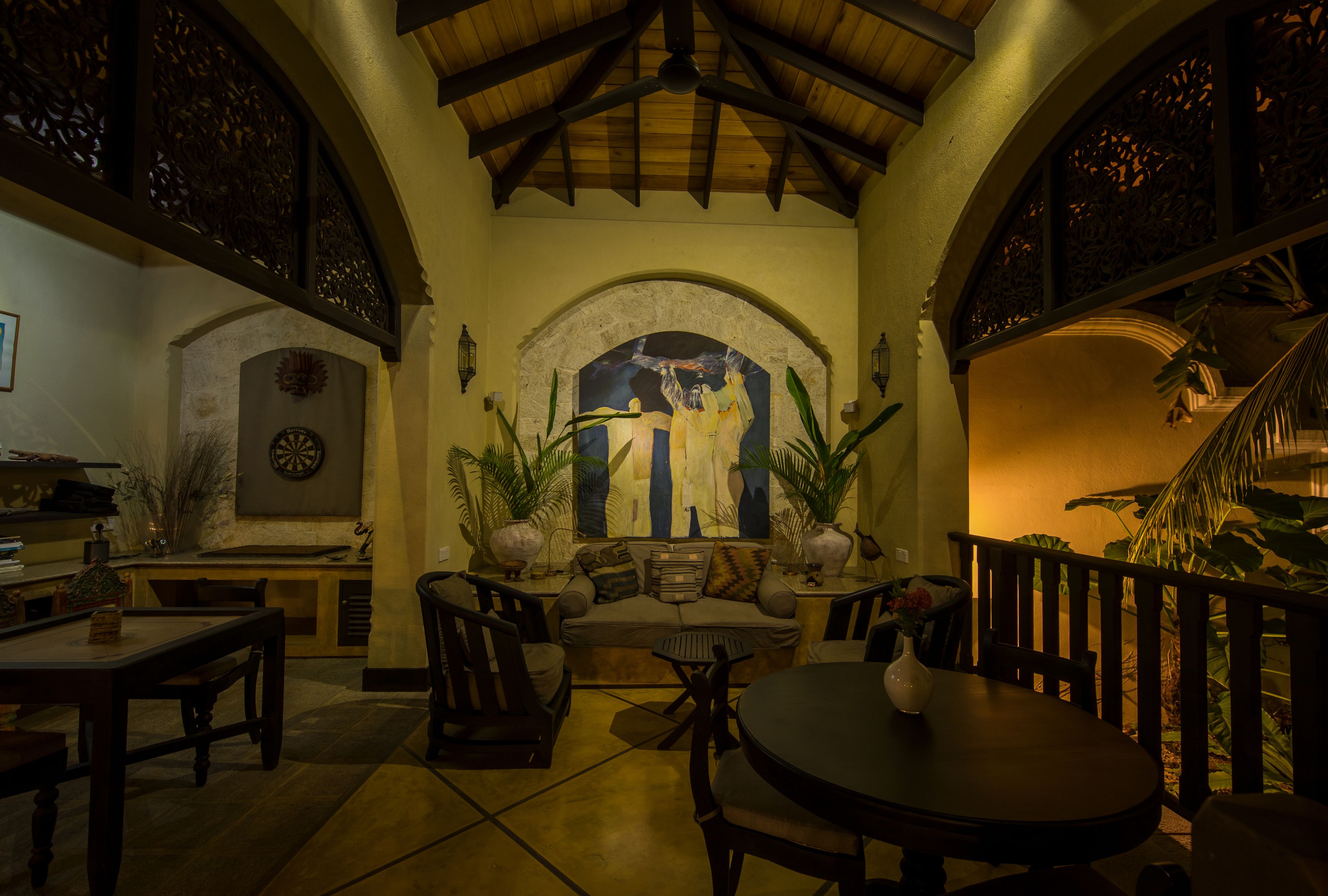 An interior with a dining area, a sofa, and a decorative archway.