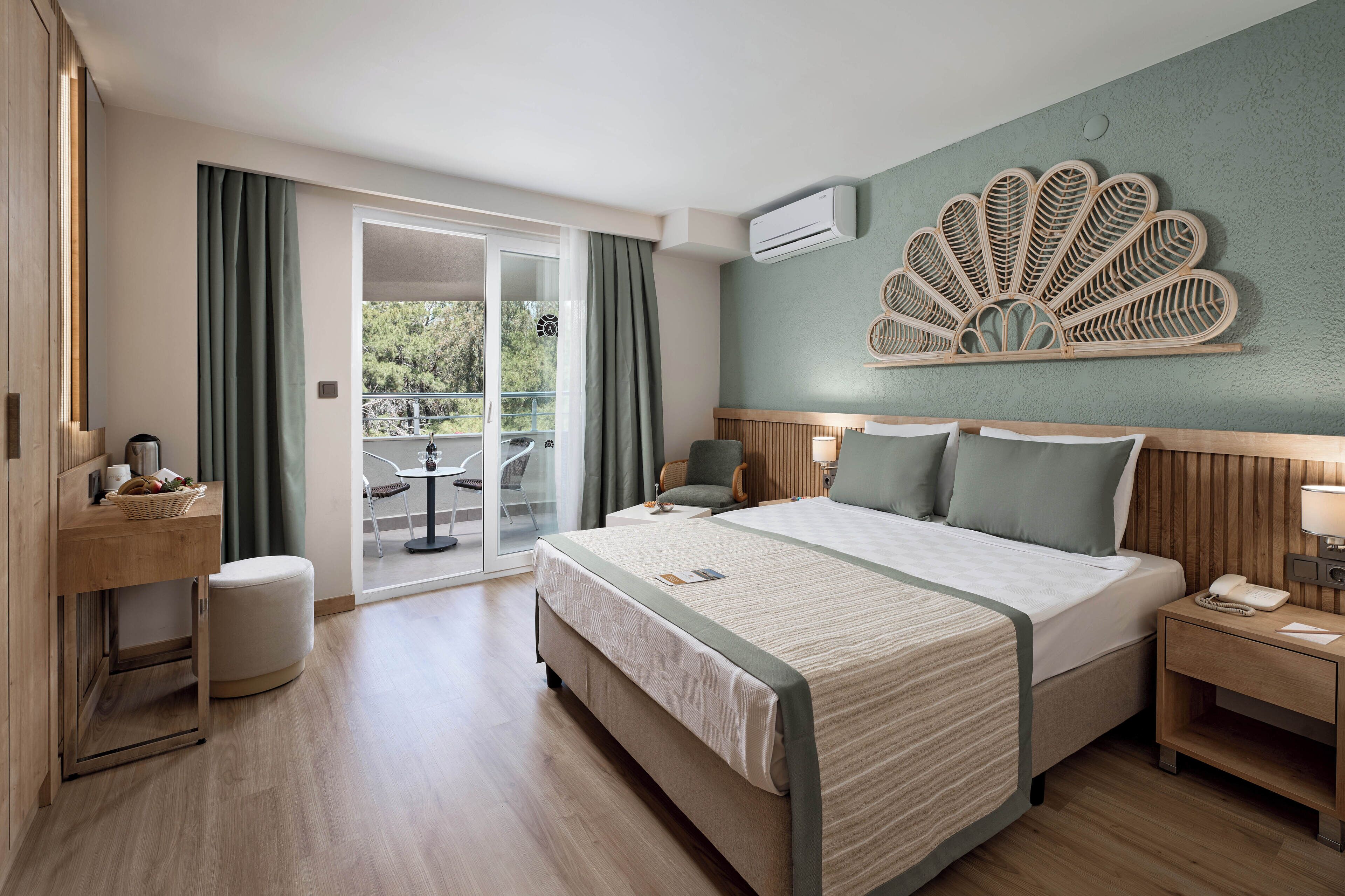 Una habitación de hotel con cama, mesita de noche y vistas al exterior.