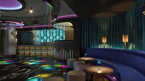 Ein stilvoller Lounge-Bereich mit Bar, Sitzgelegenheiten und stimmungsvoller Beleuchtung.