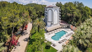 Ein Resort mit Pool, Liegestühlen und einem Turm mit Balkon.