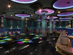 Een modern interieur met een rond plafondontwerp, een centraal podium en zitgedeeltes.