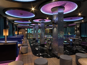 A modern interior with circular ceiling lights, a bar area, and seating. - Annabella Park Hotel (Alanya)