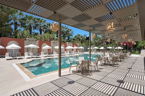 A pool area with lounge chairs and umbrellas, surrounded by palm trees and a clear sky. - Annabella Park Hotel (Alanya)