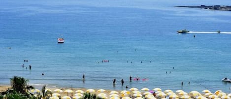 På stranden, solstolar och parasoller