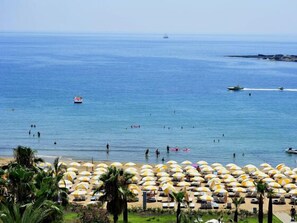 En la playa, sillas reclinables de playa, sombrillas