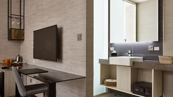 Una cocina moderna con un televisor de pantalla plana, una mesa de comedor y una cafetera.