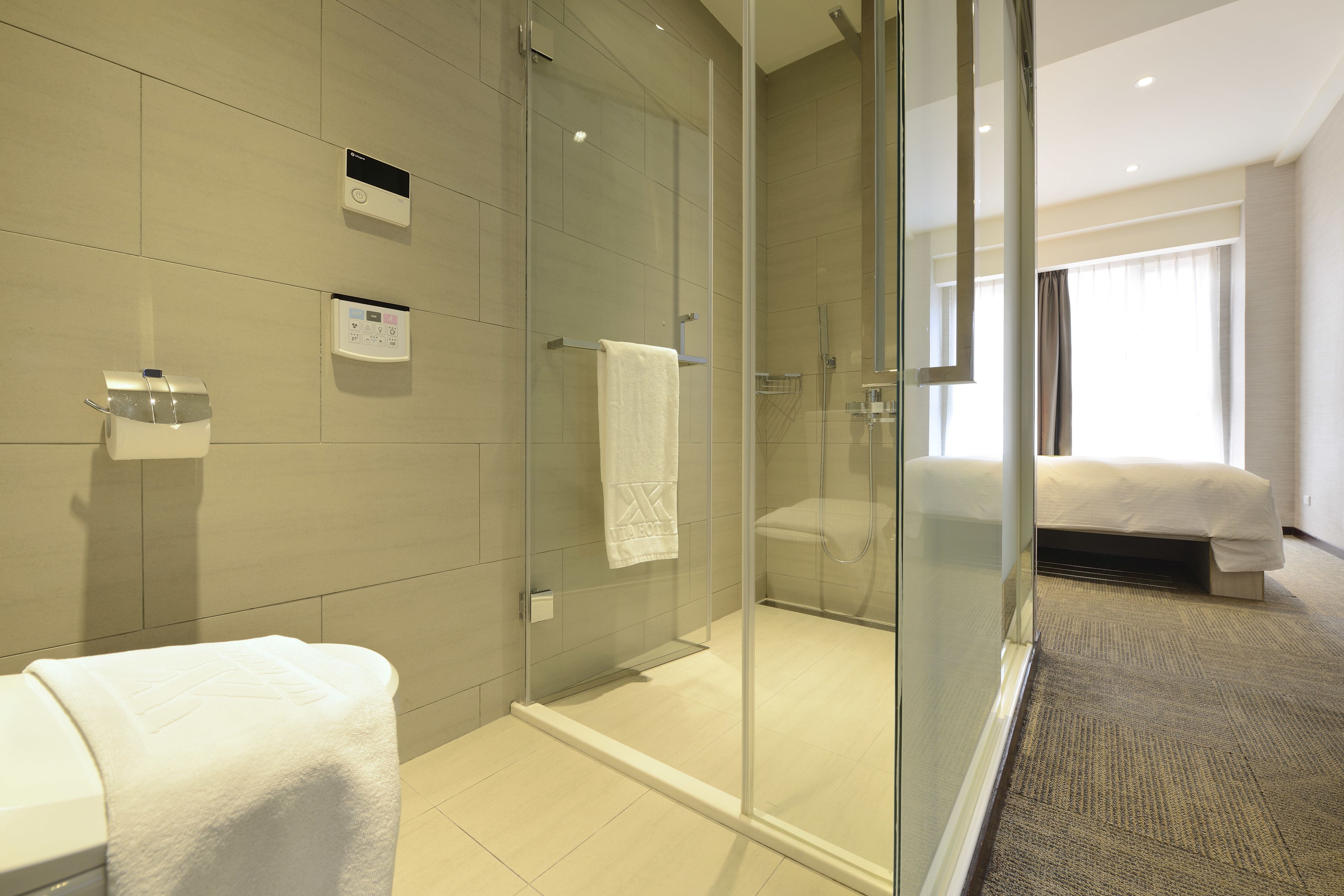 Un bagno moderno con doccia vetro, un water e un lavandino.