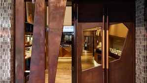 A modern interior with a central metallic structure, a wooden floor, and a visible reception area. - Via Hotel Taipei Station (Taipei)