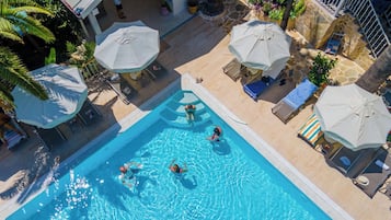 Een buitenzwembad, parasols voor strand/zwembad