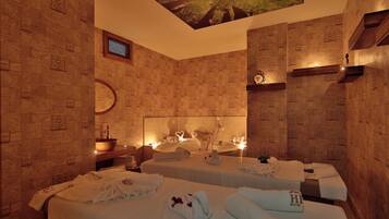 Habitación de hotel con dos camas, un espejo grande, un lavabo y un techo con diseño de árbol.
