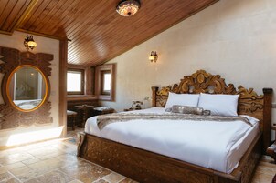 Un dormitorio amplio con una cama de madera grande, un espejo decorativo y dos lámparas de pared.